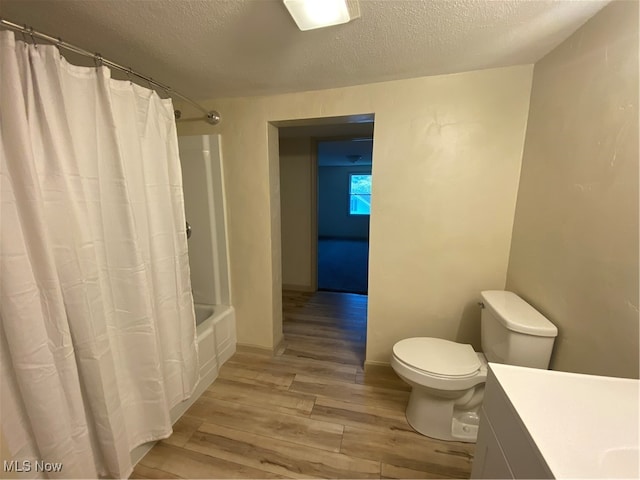 full bathroom with toilet, wood-type flooring, shower / bath combo, vanity, and a textured ceiling