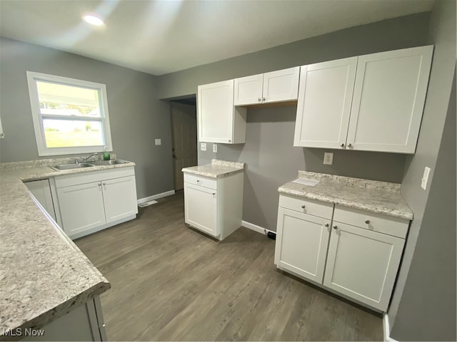 kitchen with sink, dark hardwood / wood-style flooring, and white cabinetry