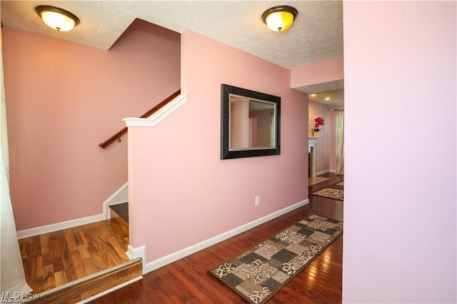 hallway featuring a textured ceiling and hardwood / wood-style floors