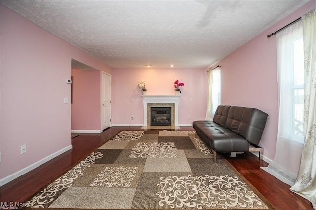 living room featuring a textured ceiling and dark hardwood / wood-style flooring