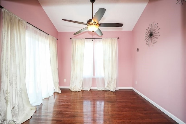 empty room with vaulted ceiling, dark hardwood / wood-style flooring, a wealth of natural light, and ceiling fan