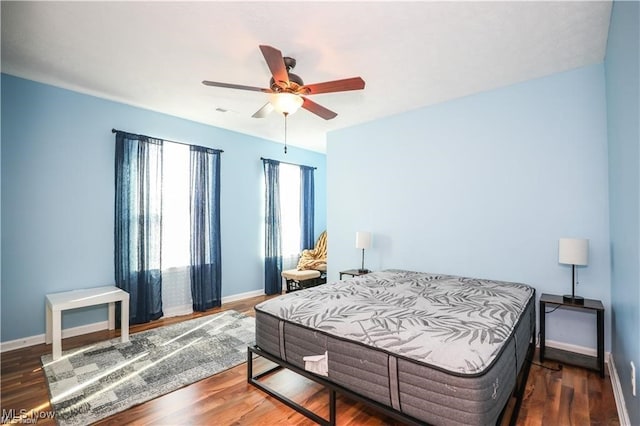 bedroom with ceiling fan and dark hardwood / wood-style floors