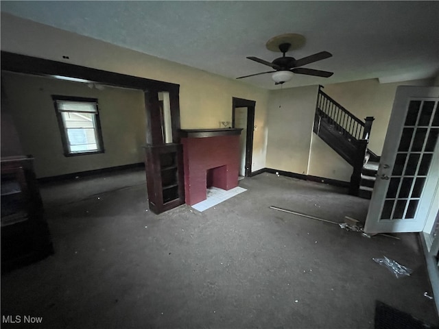 unfurnished living room with ceiling fan