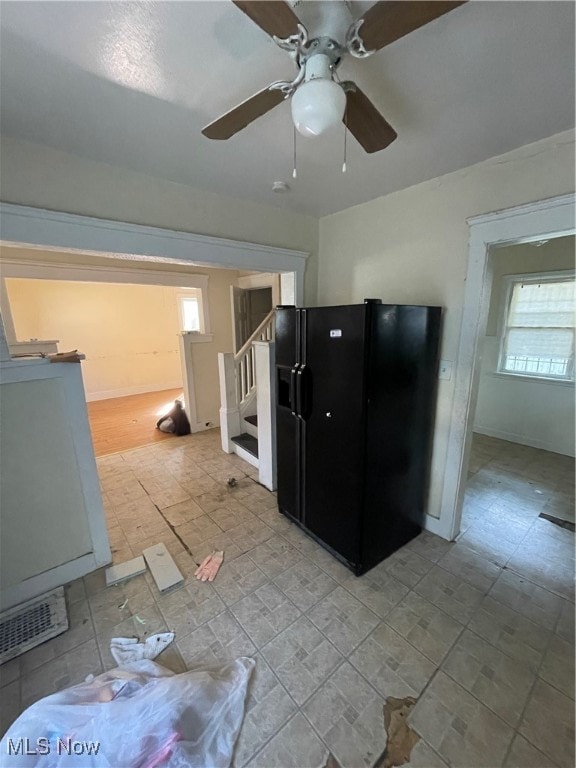 interior space with black fridge and ceiling fan