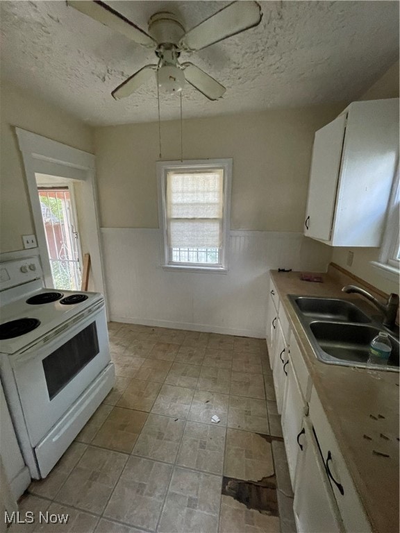 kitchen featuring sink, white cabinetry, a textured ceiling, and white range with electric stovetop