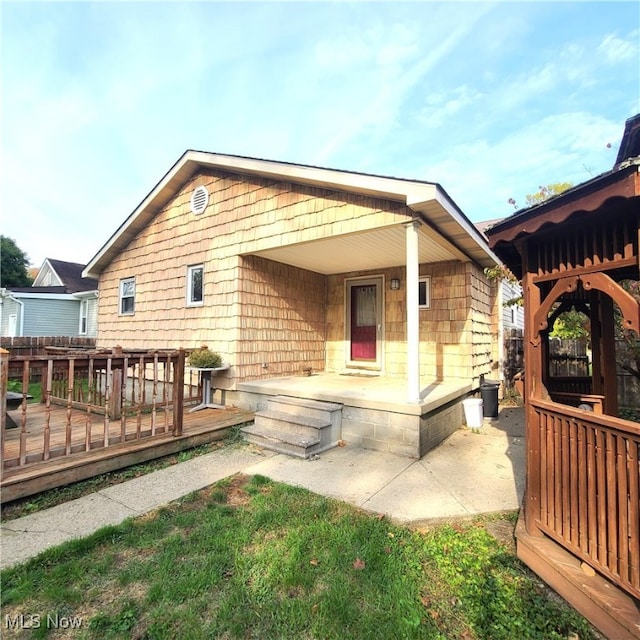 rear view of property featuring a wooden deck