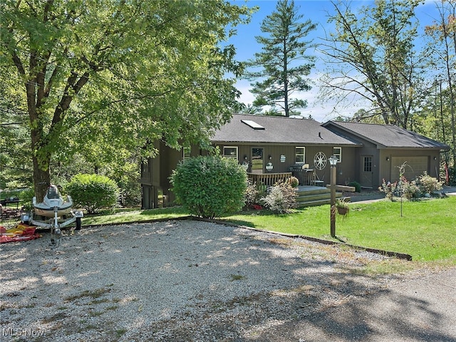 rear view of house featuring a lawn and a garage