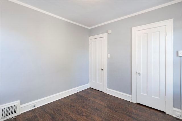 unfurnished room with ornamental molding and dark wood-type flooring