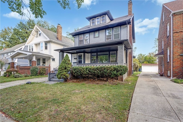 view of front of property featuring a porch, a garage, an outdoor structure, and a front yard