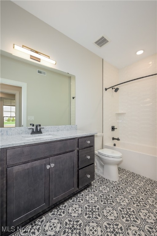 full bathroom featuring tiled shower / bath, vanity, and toilet