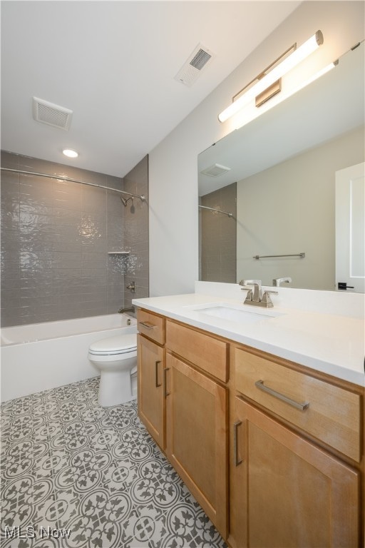 full bathroom featuring vanity, toilet, and tiled shower / bath