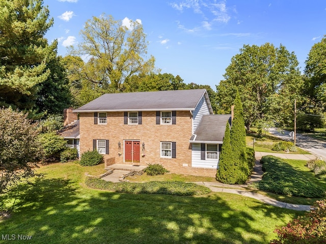 colonial-style house featuring a front yard