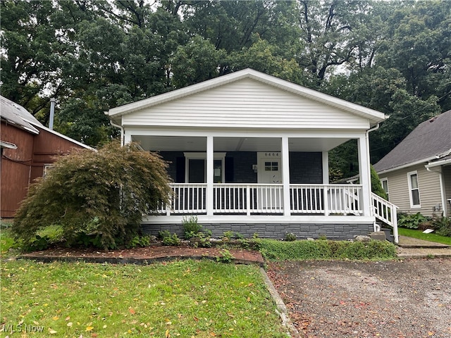 bungalow-style home with covered porch and a front yard