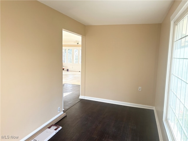 unfurnished room with a wealth of natural light and dark hardwood / wood-style floors