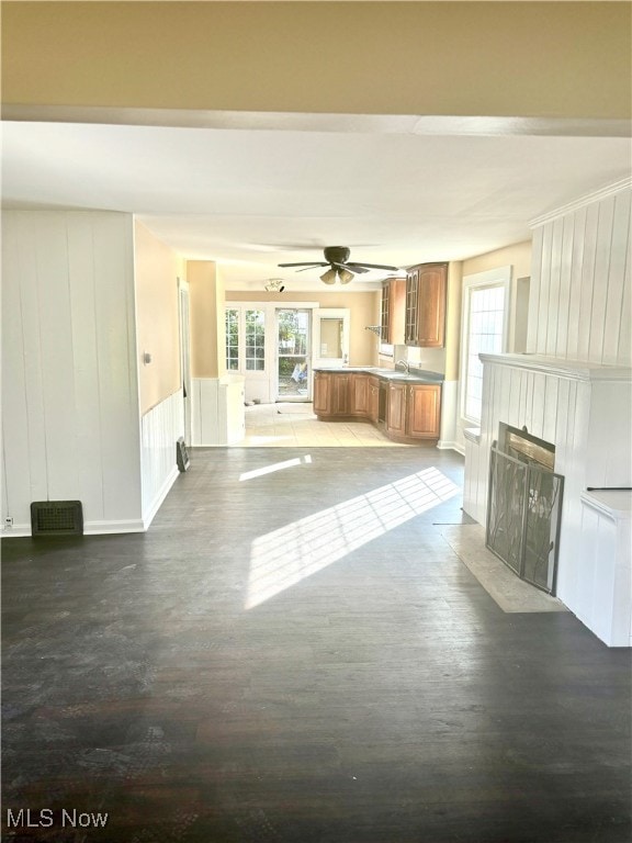 unfurnished living room featuring light wood-type flooring, ceiling fan, and sink