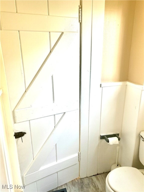 bathroom featuring hardwood / wood-style flooring and toilet