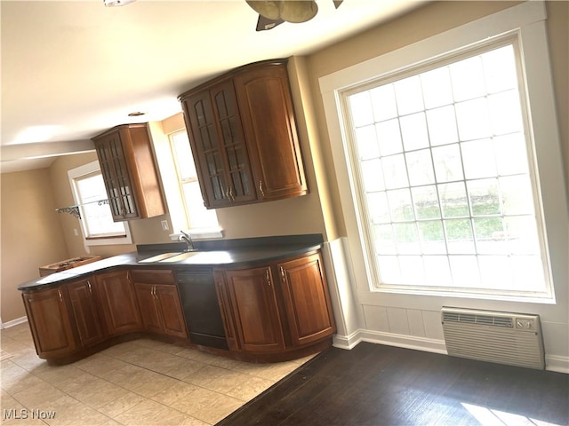 kitchen featuring ceiling fan, sink, kitchen peninsula, black dishwasher, and light wood-type flooring