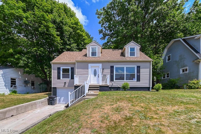 cape cod home featuring a garage and a front lawn