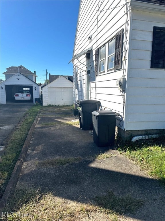 view of side of home featuring a garage and an outdoor structure