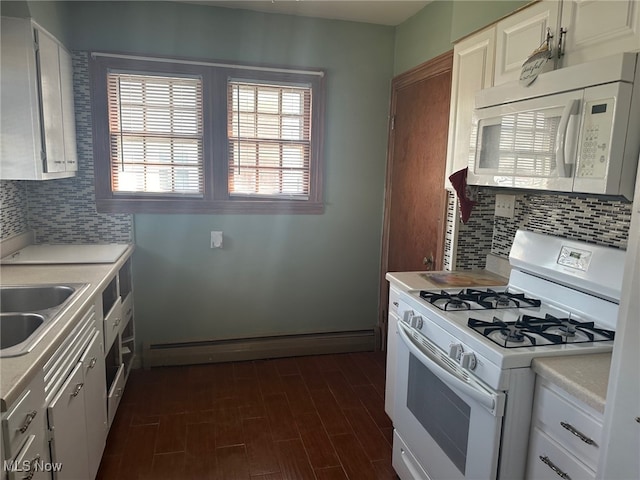 kitchen featuring white appliances, backsplash, sink, and white cabinetry