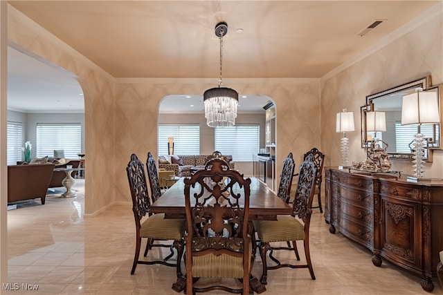 dining space with ornamental molding and an inviting chandelier