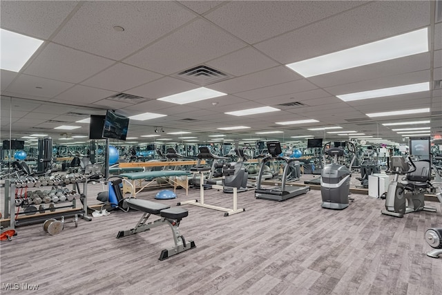 workout area with a drop ceiling and hardwood / wood-style floors