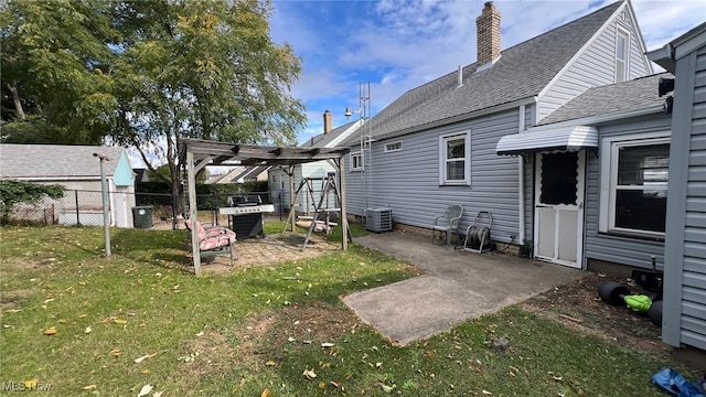 back of house featuring a pergola, central AC unit, a lawn, and a patio area