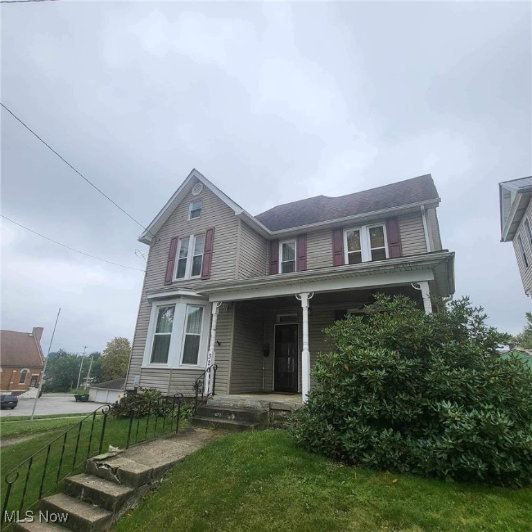 view of front of house with a front yard and covered porch