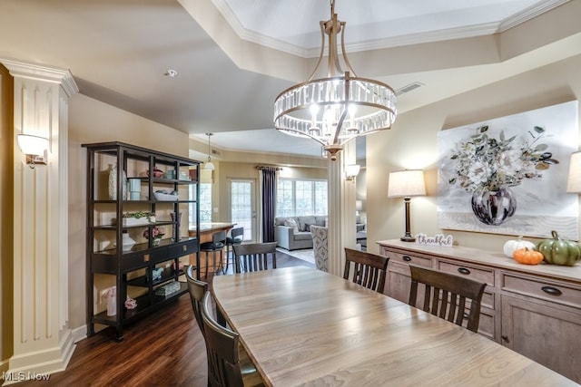 dining space featuring ornamental molding, a notable chandelier, a tray ceiling, and dark hardwood / wood-style flooring