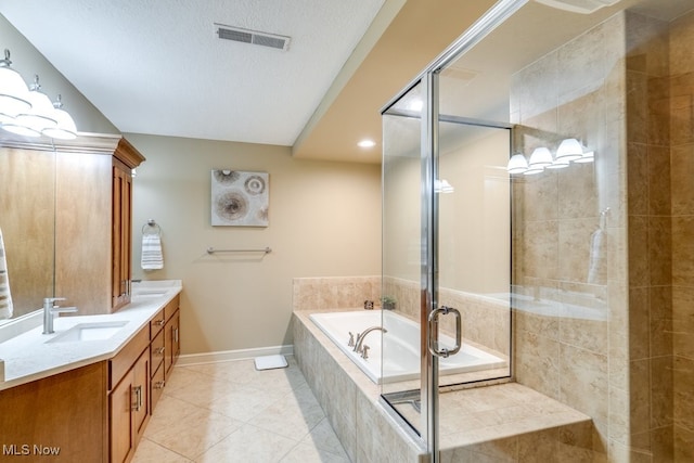 bathroom featuring independent shower and bath, vanity, a textured ceiling, and tile patterned floors