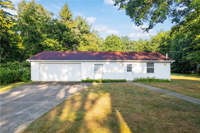 ranch-style home featuring a garage and a front lawn