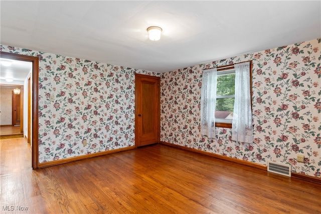 unfurnished room with wood-type flooring