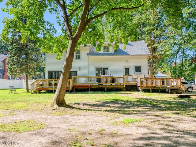 rear view of house with a deck and a lawn