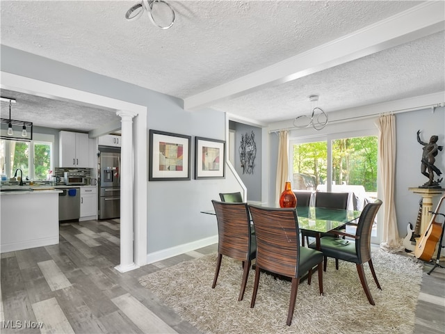 dining room featuring plenty of natural light, light hardwood / wood-style floors, and a textured ceiling