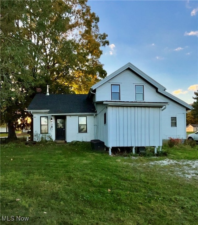 back of property featuring a lawn