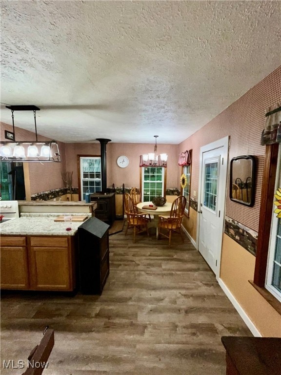 kitchen featuring decorative light fixtures, dark hardwood / wood-style flooring, a textured ceiling, and a wood stove