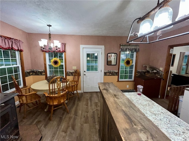 dining room with an inviting chandelier, dark hardwood / wood-style floors, and a textured ceiling