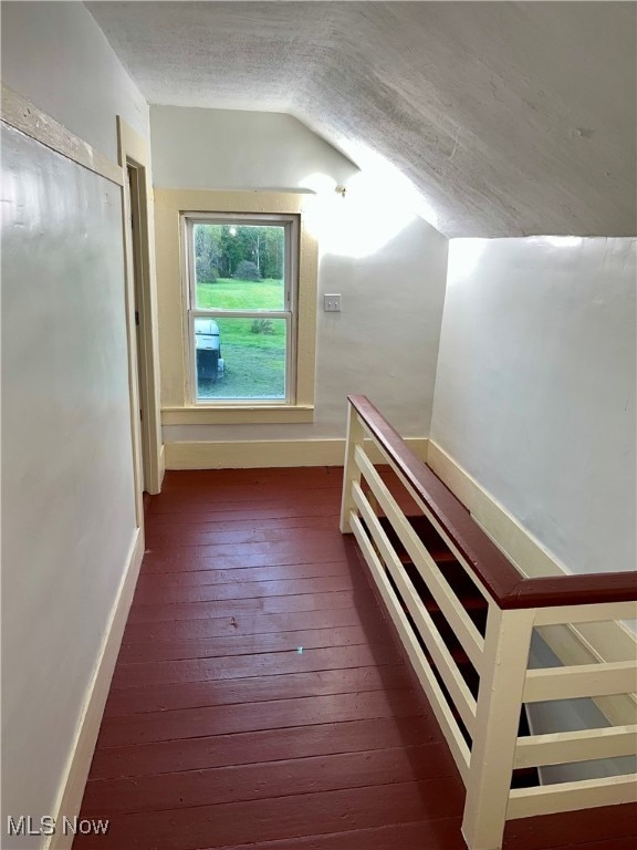 additional living space with dark hardwood / wood-style floors and vaulted ceiling