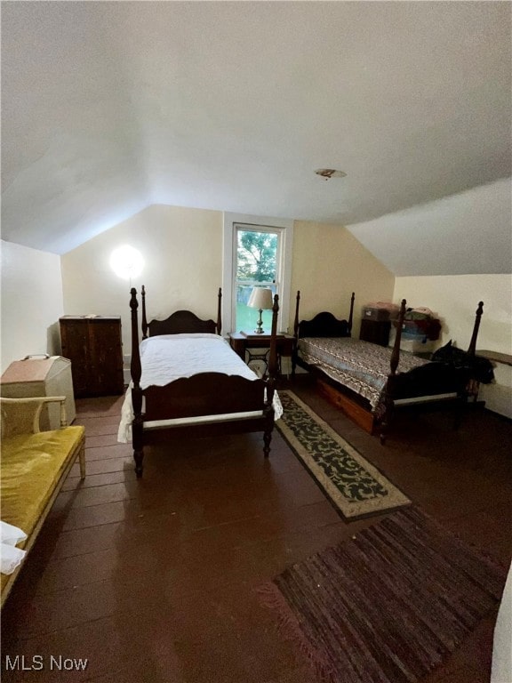 bedroom with lofted ceiling and a textured ceiling