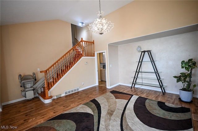 foyer featuring a notable chandelier, hardwood / wood-style flooring, and vaulted ceiling