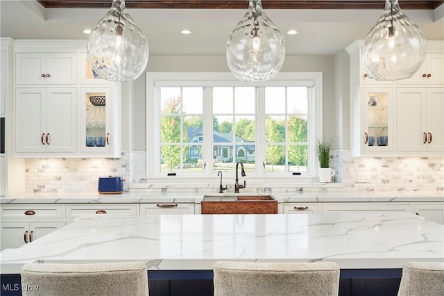 kitchen with plenty of natural light, sink, and white cabinets