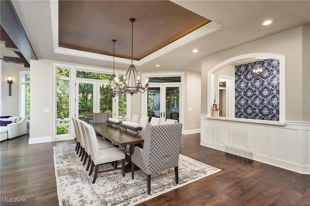 dining space featuring a raised ceiling, dark hardwood / wood-style floors, and french doors