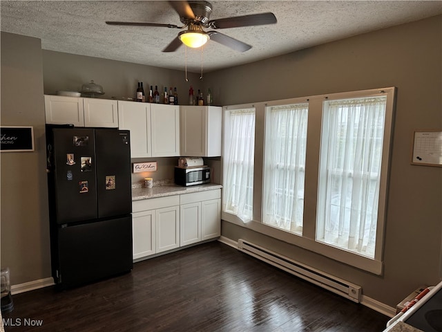 kitchen with a baseboard radiator, black refrigerator, dark hardwood / wood-style floors, and white cabinets