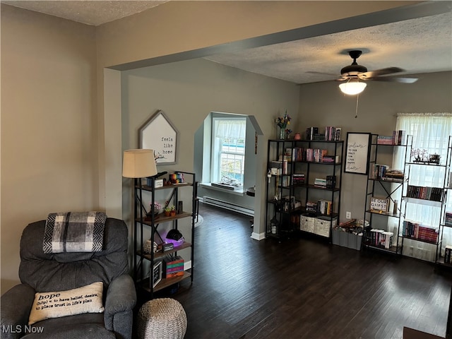 sitting room featuring a textured ceiling, ceiling fan, a baseboard radiator, and dark hardwood / wood-style flooring