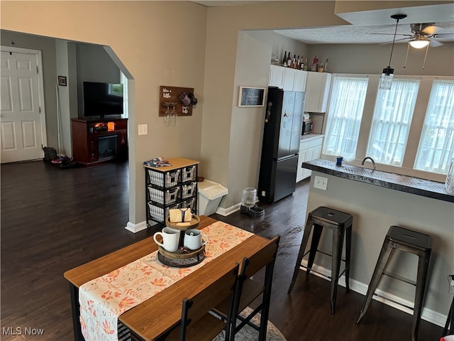 dining room with ceiling fan and dark hardwood / wood-style flooring