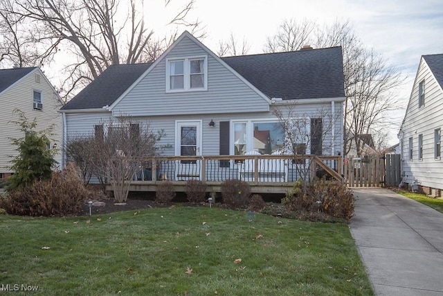 cape cod house with a deck and a front lawn