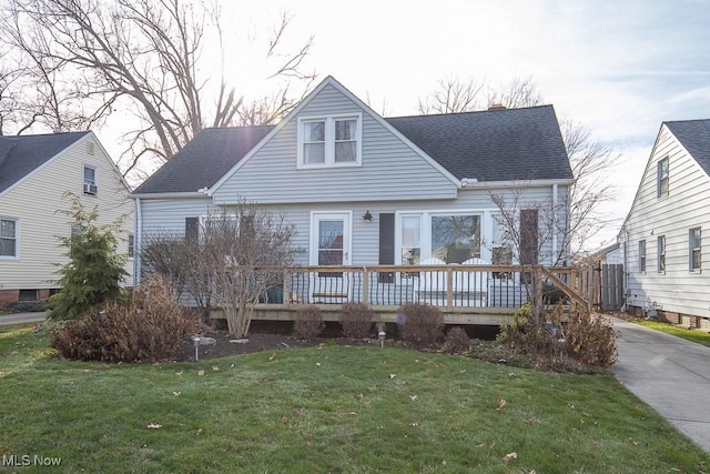 view of front facade with a wooden deck and a front yard