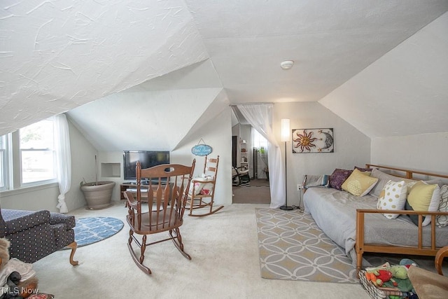 bedroom featuring a textured ceiling, light colored carpet, and vaulted ceiling