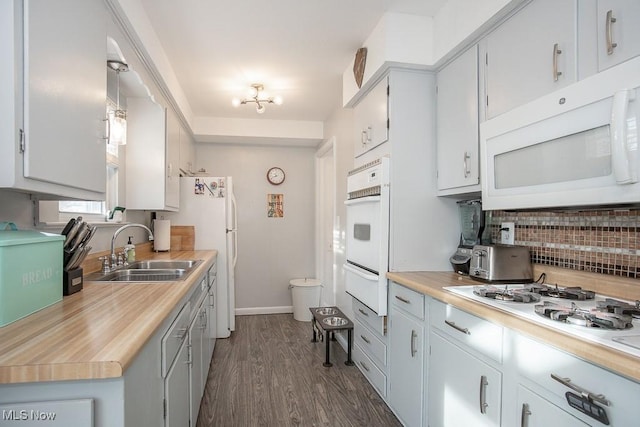 kitchen featuring white cabinetry, white appliances, sink, and dark wood-type flooring