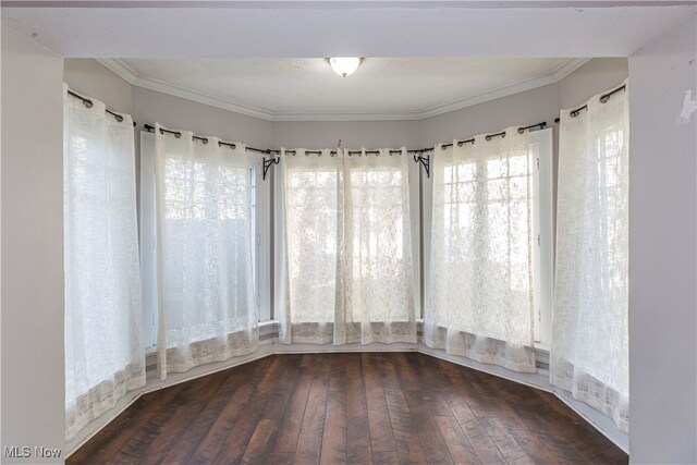 empty room with ornamental molding and dark hardwood / wood-style flooring